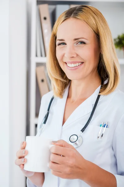 Médecin en uniforme blanc tenant tasse — Photo