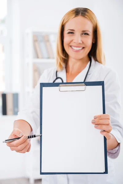 Doctor stretching out clipboard — Stock Photo, Image