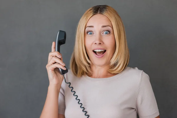 Mujer sorprendida sosteniendo el teléfono —  Fotos de Stock