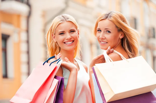 Vrouw en haar dochter uitvoering shopping tassen — Stockfoto