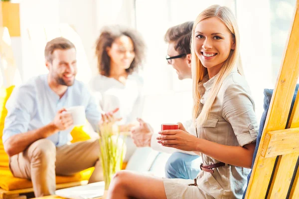 Femme tenant une tasse de café avec des collègues — Photo