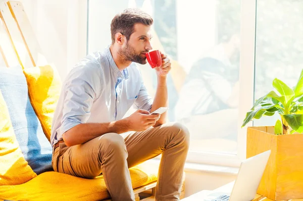 Homme tenant le téléphone et buvant du café — Photo