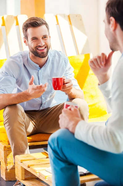 Men holding cups and discuss something — Stock Photo, Image