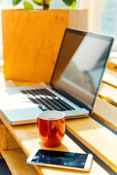 Escrivaninha com laptop e telefone celular — Fotografia de Stock