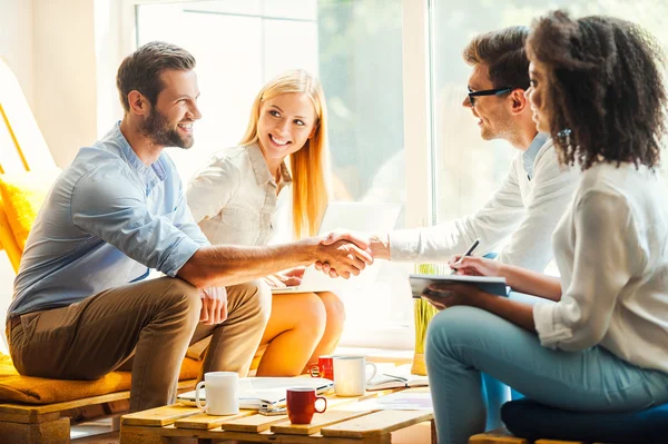 Frauen arbeiten und Männer schütteln Hände Stockbild