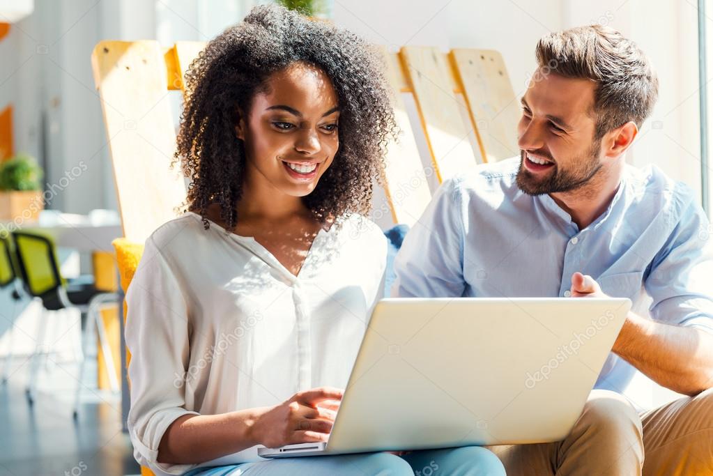 African woman working on laptop with man