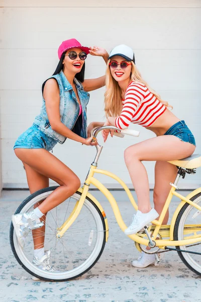 Woman sitting on bicycle with friend behind — Stock Photo, Image