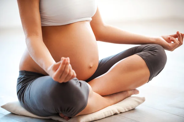 Mujer embarazada meditando en posición de loto — Foto de Stock