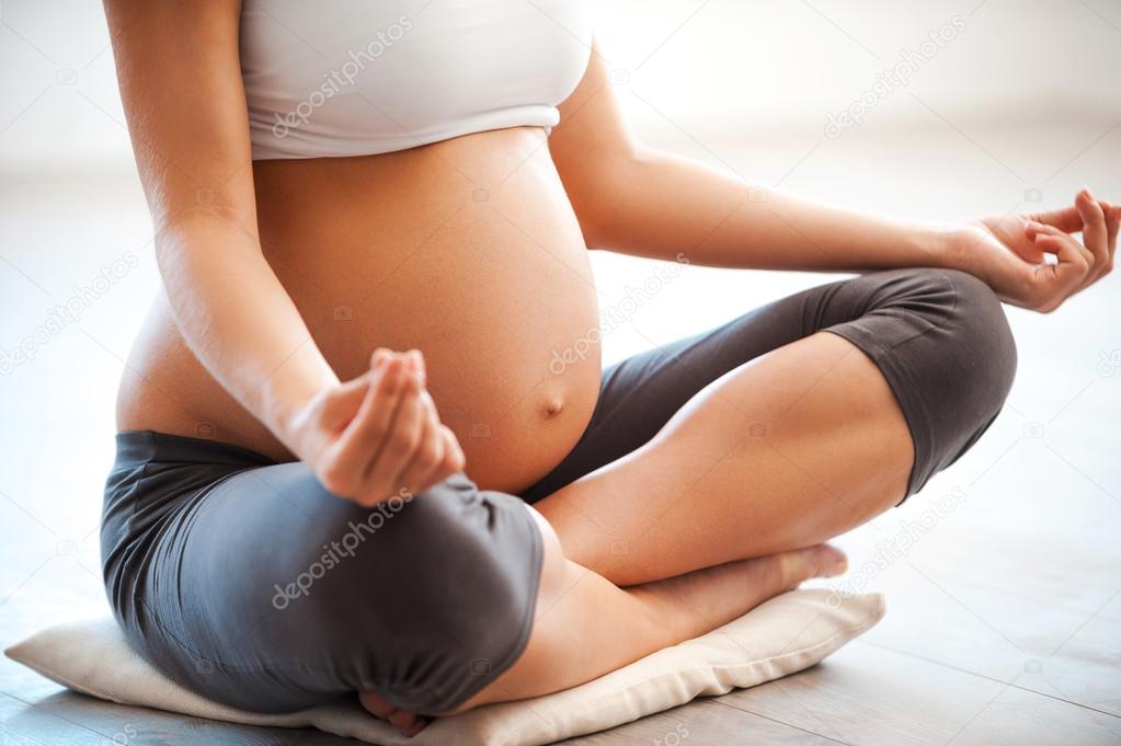 pregnant woman meditating in lotus position
