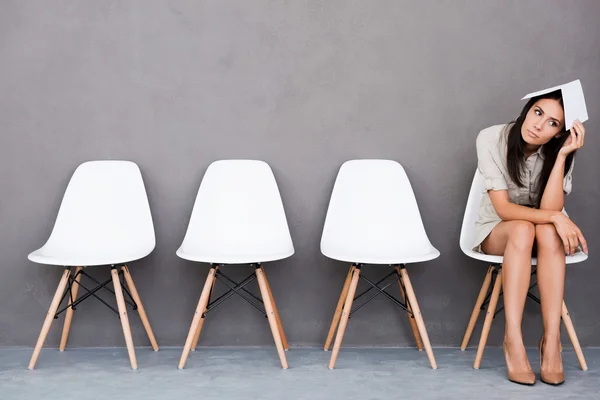 Bored  businesswoman holding paper on head — Stock Photo, Image