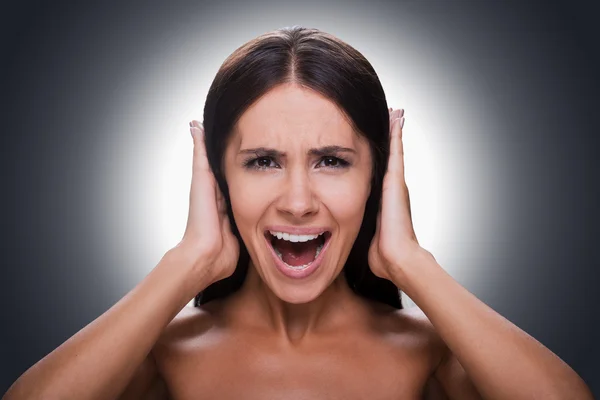 Woman shouting and covering ears by hands — Stockfoto