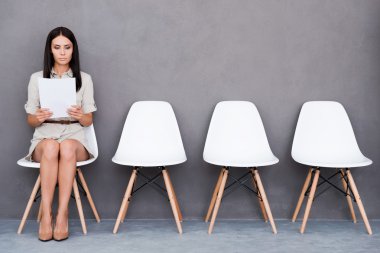businesswoman holding paper while sitting on chair