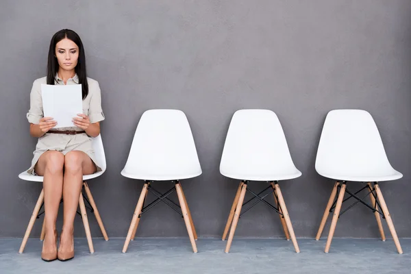 Mujer de negocios sosteniendo papel mientras está sentada en la silla —  Fotos de Stock