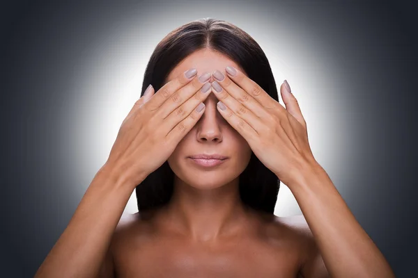 shirtless woman covering eyes by hands