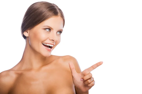 Shirtless woman pointing away and smiling — Stock Photo, Image