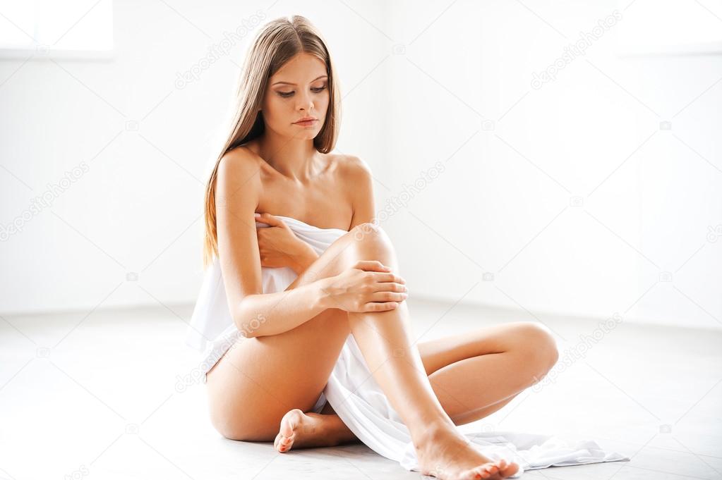 naked woman covering herself with  textile