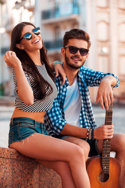 Loving couple sitting outdoors with guitar — Stock Photo, Image