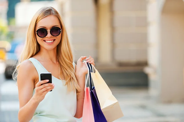 Mujer sosteniendo bolsas de compras y teléfono — Foto de Stock