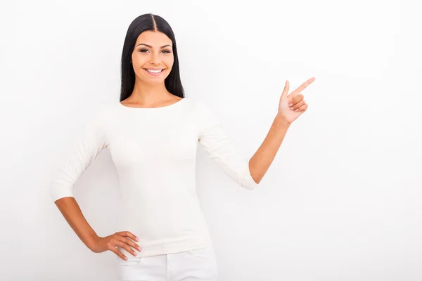 Woman holding hand on hip and pointing away — Stock Photo, Image