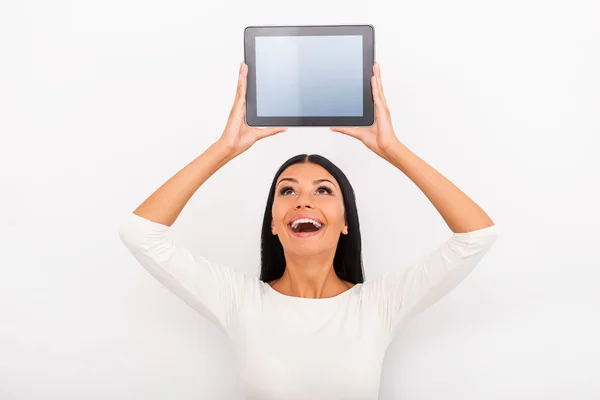 Mujer sosteniendo tableta digital por encima de su cabeza — Foto de Stock