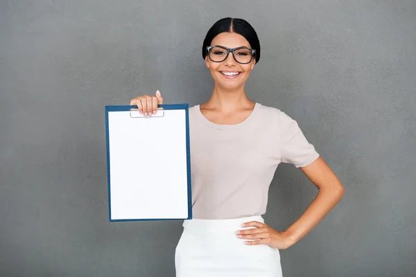 Businesswoman stretching out clipboard — Zdjęcie stockowe