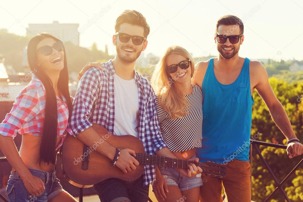 young people standing on the roof with guitar