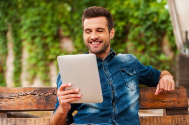 adam holding dijital tablet açık havada