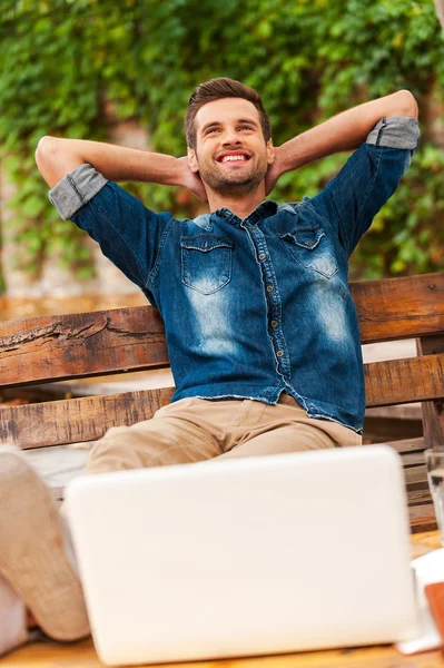 Homme penché sur un banc en bois à l'extérieur — Photo