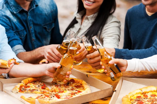 Insanlar yemek pizza ve prangalara şişeler — Stok fotoğraf