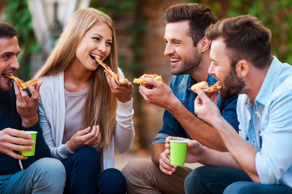 Jeunes gens joyeux manger de la pizza — Photo