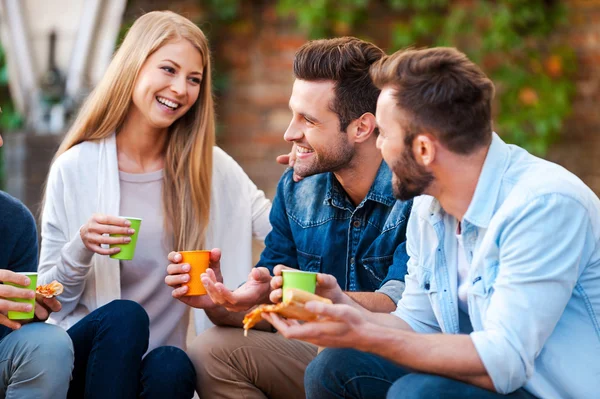 Jovens conversando e comendo pizza — Fotografia de Stock