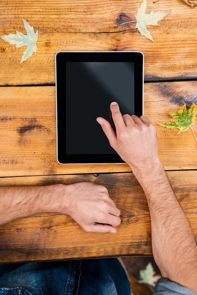 man holding his finger on digital tablet