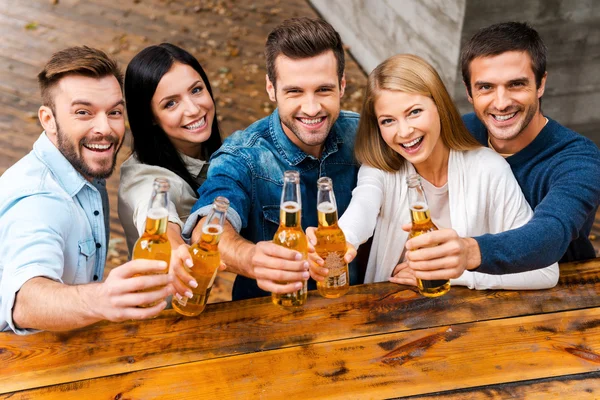 Jonge mensen strekken flessen met bier — Stockfoto