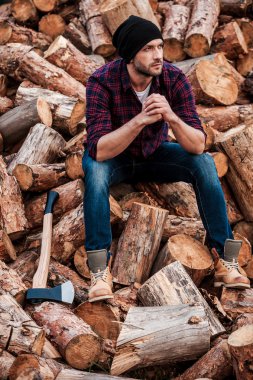 günlükleri üzerinde oturan düşünceli genç forester