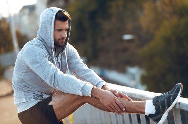 çalıştırmadan önce bacaklarını esnetiyor adam