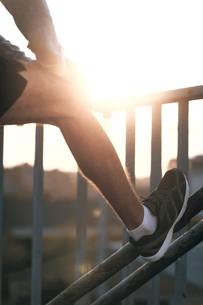 Hombre estirando su pierna antes de correr — Foto de Stock