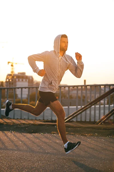 Jeune homme courant le long du pont — Photo