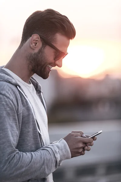 Homem em óculos de sol segurando telefone celular — Fotografia de Stock