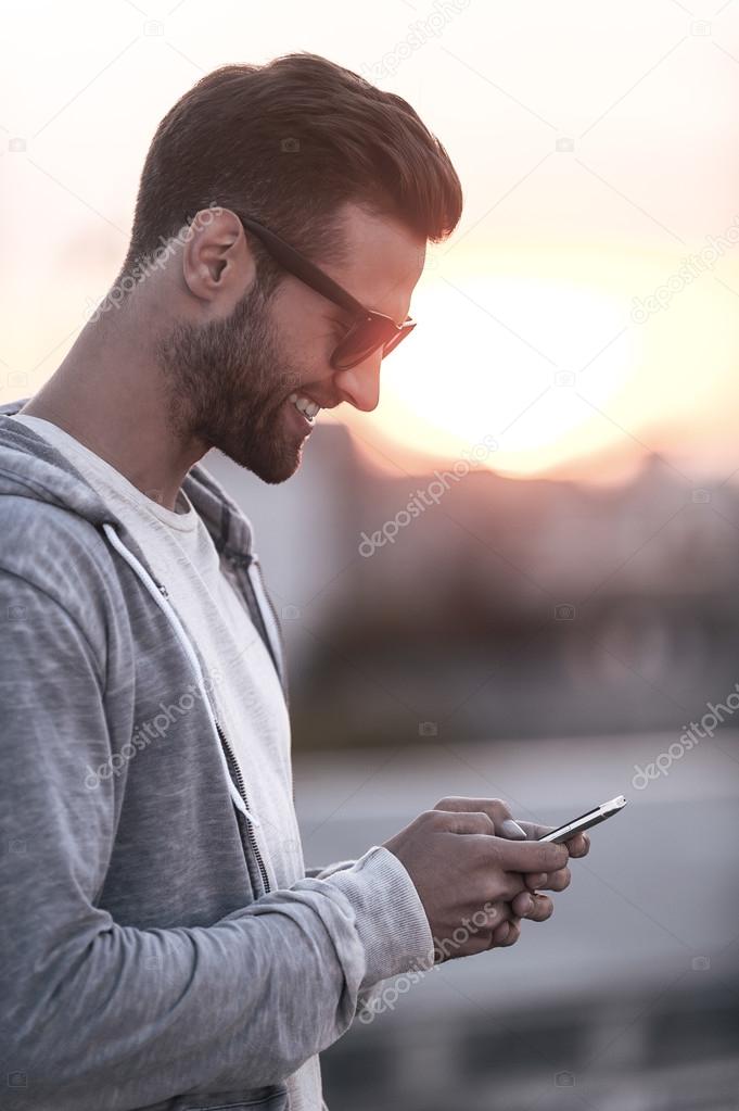 man in sunglasses holding mobile phone
