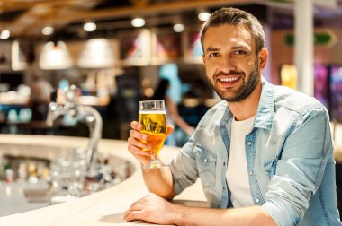 man with glass of beer at bar counter