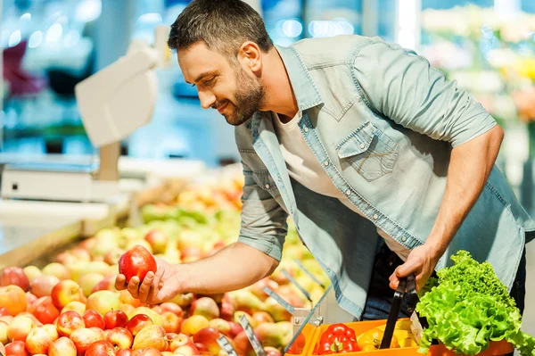 Hombre sosteniendo manzana y cesta de la compra — Foto de Stock