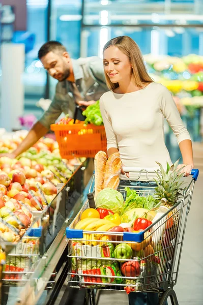 Giovane coppia che sceglie i prodotti nel supermercato — Foto Stock