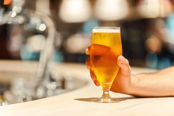 Male hand holding glass of beer — Stock Photo, Image