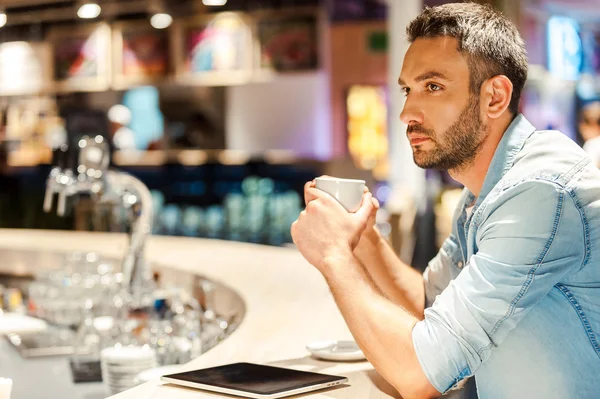 Man with cup of coffee at the bar counter — Stock fotografie