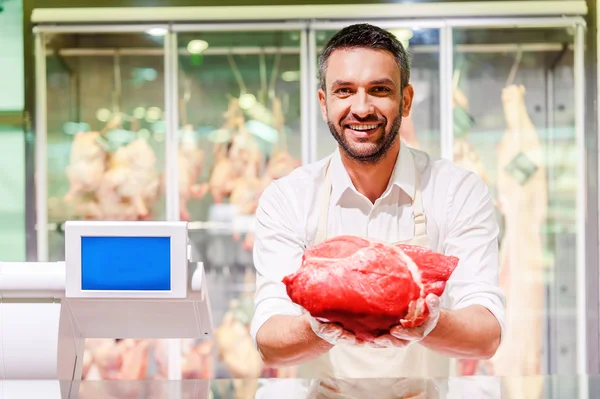 Carnicero estirando rebanada de carne — Foto de Stock