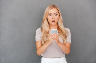 Surprised woman holding mobile phone