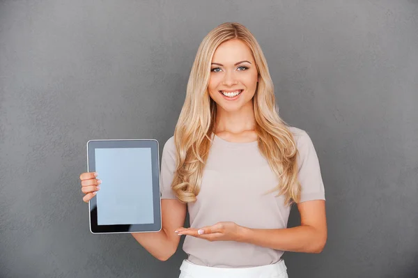 Woman holding digital tablet and pointing at it — Stock Photo, Image