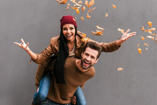 Mann wirft Huckepack mit Laub auf Freundin — Stockfoto