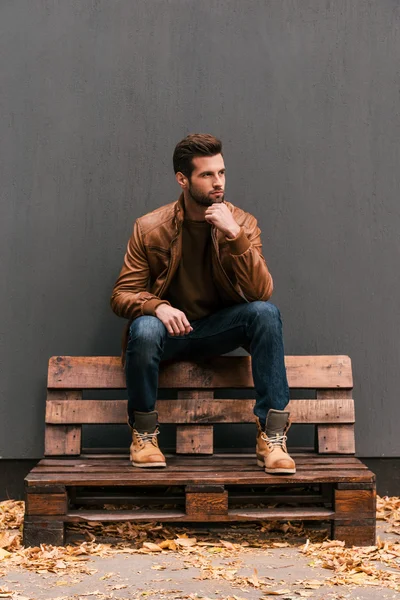 Thoughtful man sitting on the wooden pallet — Stock Photo, Image