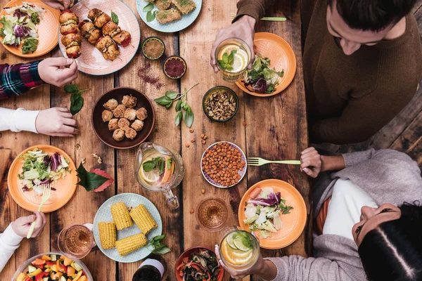 Mensen die diner aan de rustieke tafel — Stockfoto
